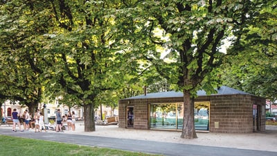 Pavillon mit Bäumen und Besuchern im Park.