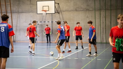 Junge beim Hallenfussballspiel in Sporthalle.",