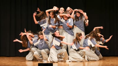 Gruppe von Tänzerinnen auf der Bühne in dynamischer Pose.
