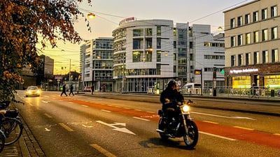 Strassenszene in der Stadt bei Sonnenuntergang mit Motorradfahrer in Basel.