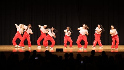 Gruppe von Tänzerinnen in roten Hosen auf der Bühne.
