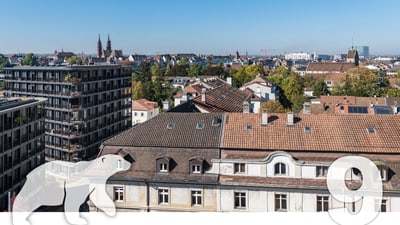 Stadtansicht von Basel mit Gebäuden und Bäumen.