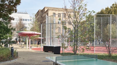 Spielplatz mit Tischtennisplatte und Basketballkäfig.