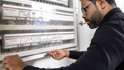 Elektriker arbeitet an einem Schaltschrank.