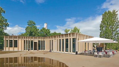 Modernes Gebäude mit Terrasse und Sonnenschirm.