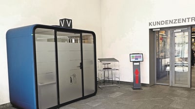 Blaue Kabine und Kundenzentrum-Eingang mit Infotafel.