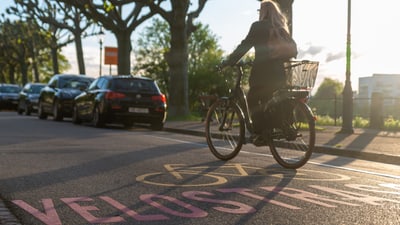 Frau fährt mit dem Velo auf einer Velostrasse