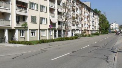 Mehrfamilienhaus an leerer Strasse.