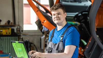 Mechaniker bei der Arbeit am Laptop in der Werkstatt.