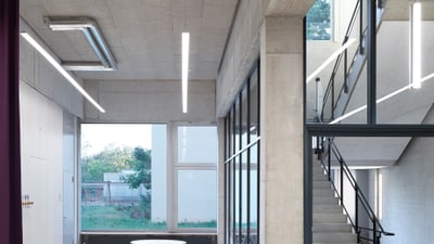 Treppenhaus und Eingangsbereich mit Sichtbeton und grossem Fenster.