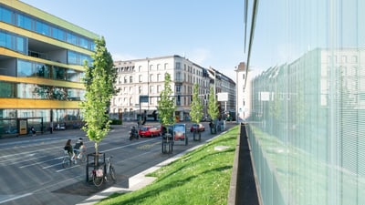 Strassenszene in einer Stadt mit moderner und historischer Architektur.