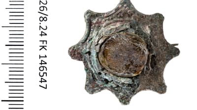 Antiker metallener Knopf mit Messskala und Text links.