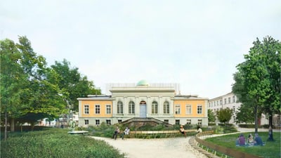Historisches Gebäude mit Park und Bäumen im Vordergrund.