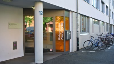 Eingang eines modernen Gebäudes mit Fahrradständer.