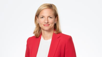 Esther Keller in rotem Blazer vor weissem Hintergrund.