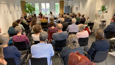 Menschenmenge bei einer Vortragsveranstaltung im Raum.