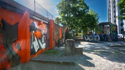Städtische Szene mit Graffiti-Wänden und Bäumen.
