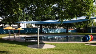 Schwimmbad mit Sonnenschirmen im Freien.