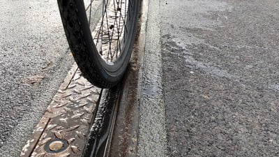 Ein Velo fährt auf dem Tramgleis