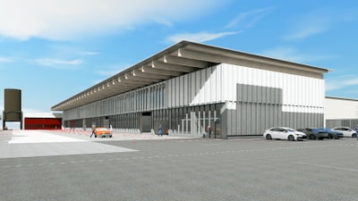 Modernes Gebäude mit Autos und Menschen auf Parkplatz bei blauem Himmel.