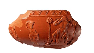 Fragment eines antiken Keramikartefakts mit Figurenreliefs.
