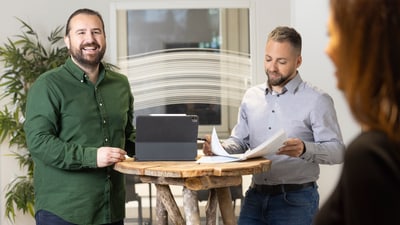 Drei Personen in einem Büro bei einem Gespräch.