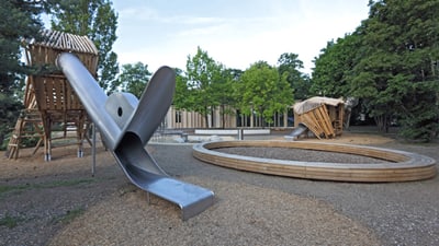 Spielplatz mit Rutsche und Klettergerüst.