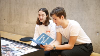 Zwei Jugendliche lesen iin einer Ausstellung.