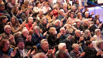 Freiwillige sitzen auf einer Treppe und applaudieren
