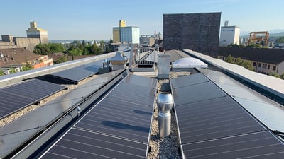 Sonnenkollektoren auf dem Dach eines Gebäudes in der Stadt.