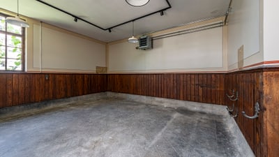 Leerer Raum mit Holzvertäfelung und grauem Boden.