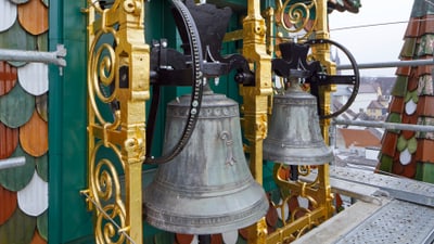 Kirchenglocken auf dem Dach mit dekorativen Elementen.