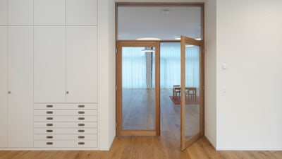 Moderner Raum mit Holzfussboden, Schrank und Glastür.