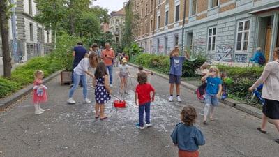 Kinder spielen mit Seifenblasen auf der Strasse.
