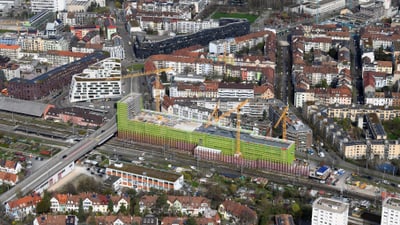 Luftaufnahme einer Stadt mit Gebäuden und Baustelle.