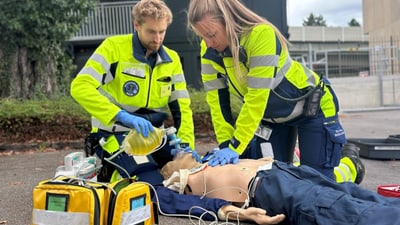 Sanitäter bei Erster-Hilfe-Übung mit Puppe im Freien.