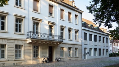 Historisches Gebäude mit Balkon und Fahrrädern davor.