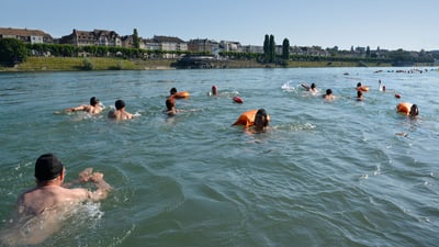 Menschen schwimmen im Rhein in Basel.