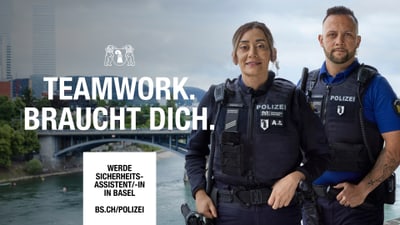 Zwei Polizisten vor einem Fluss mit Brücke.