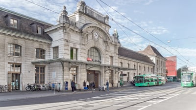 Strassenansicht des Bahnhofs Basel SBB mit Strassenbahnen.