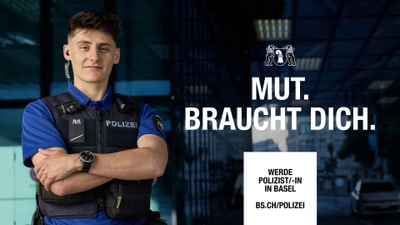 Junger Polizist in Uniform steht mit verschränkten Armen.