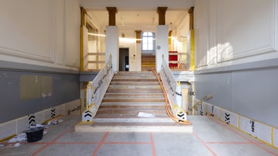 Renovierungsarbeiten an einer breiten Treppe in einem Gebäude.