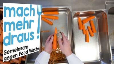 Hände schälen Karotten in der Küche.