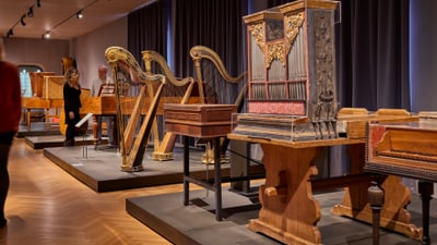 Menschen betrachten antike Musikinstrumente in einem Museum.