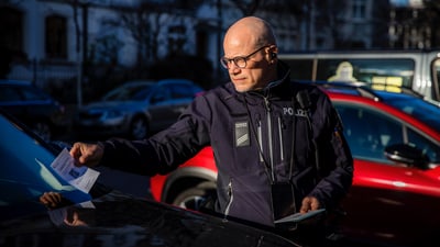 Ein Sicherheitsassistent verteilt eine Ordnungsbusse