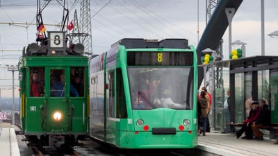 Foto der Haltestelle Weil am Rhein Bahnhof/Zentrum am Bahnhof Weil am Rhein anlässlich der Eröffnung der Tramlinie 8 im Jahr 2014. Auf dem Bild steht an der Haltestelle ein neues Tram der Linie 8 neben einem Tram der Oldtimer-Flotte.