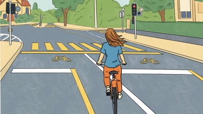 Person auf einem Fahrrad an einer Kreuzung.