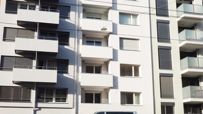 Moderne Wohngebäude mit geparkten Autos davor.