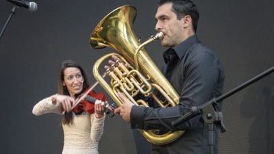 Mann spielt Euphonium, Frau spielt Geige auf der Bühne.