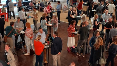 Menschen unterhalten sich bei einer Networking-Veranstaltung in einem Saal.